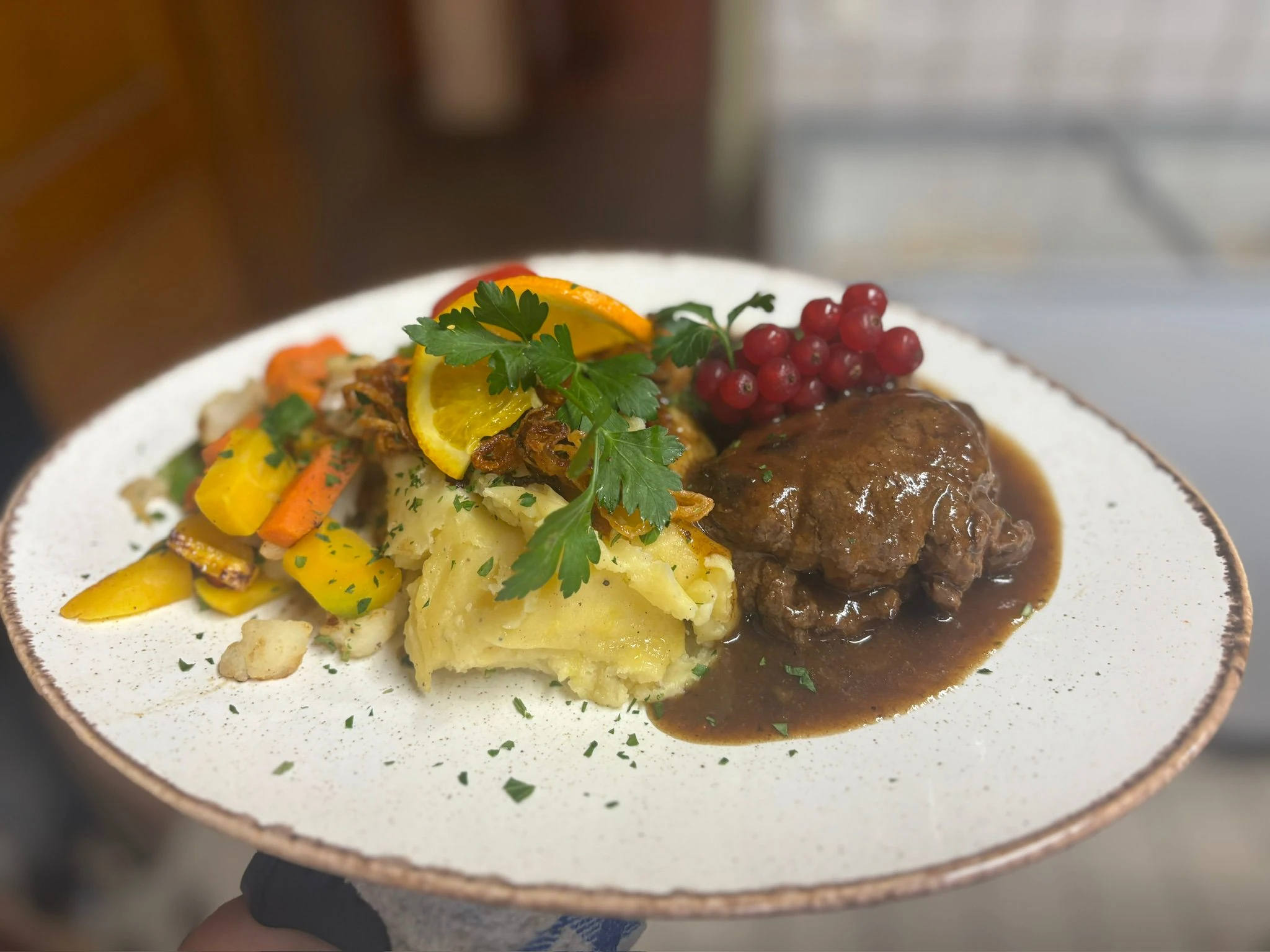 Braten in dunkler Sauce mit Kartoffelstampf, Marktgemüse und Preiselbeeren
